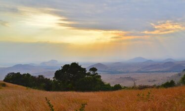 a field with grass, and a sunset 5 days Chyulu hills Safari